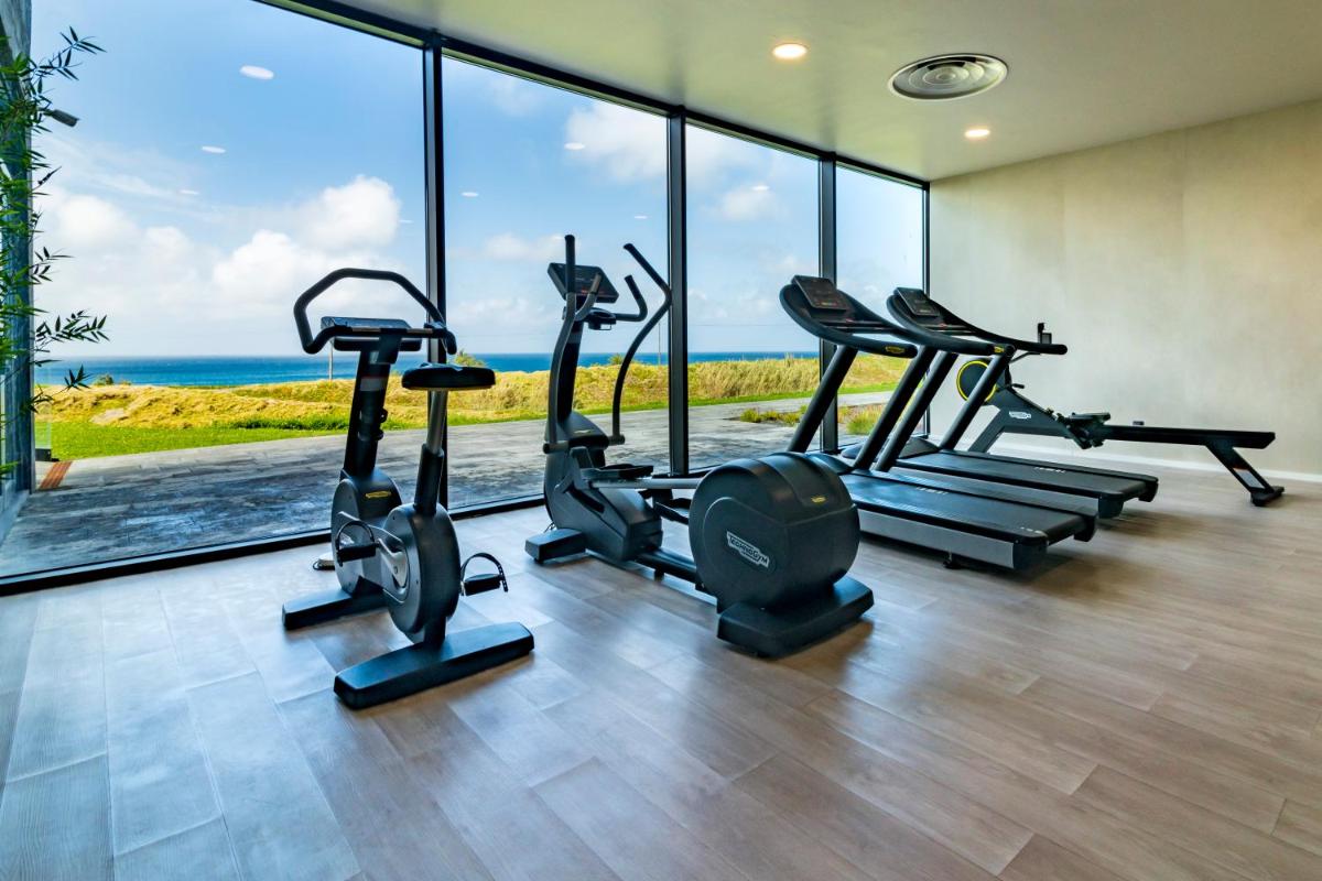 um ginásio com máquinas de cardio e vista para o oceano em Hotel Verde Mar & SPA na Ribeira Grande