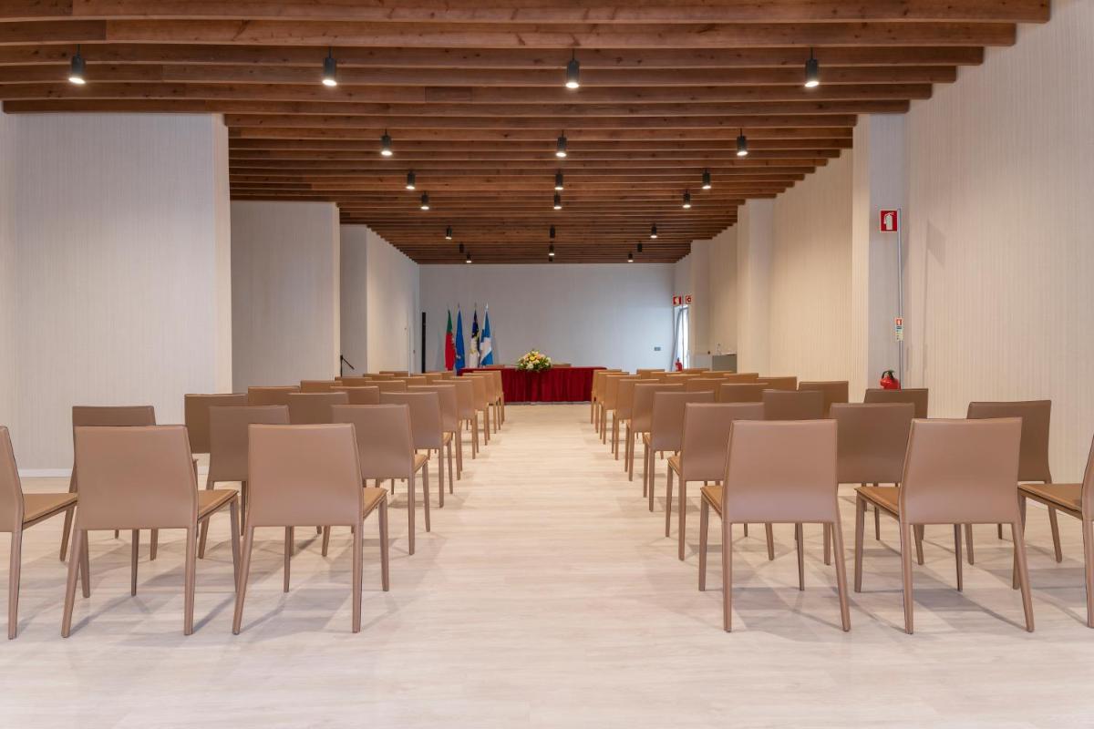 uma fila de cadeiras e mesas num quarto em Hotel Verde Mar & SPA na Ribeira Grande