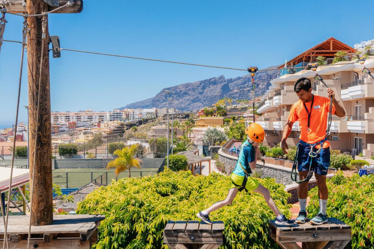 Un hombre y un niño pequeño en una tirolina en Landmar Costa los Gigantes Family Resort, en Puerto de Santiago