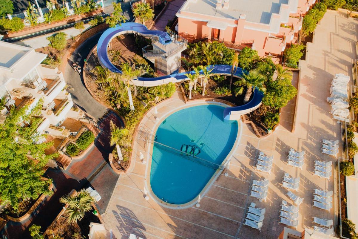 Una vista aérea de una piscina en un complejo turístico. en Landmar Costa los Gigantes Family Resort, en Puerto de Santiago