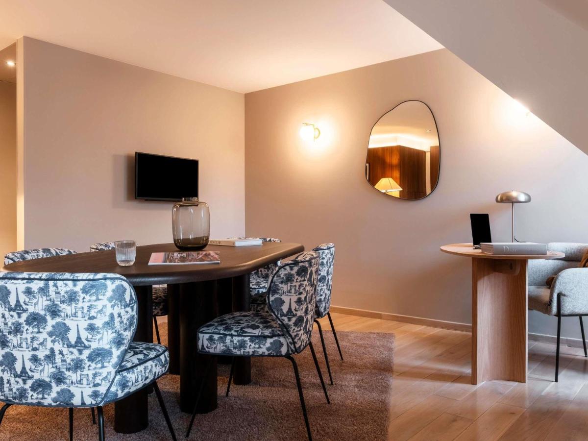 une pièce avec une table avec des chaises et un miroir dans l'établissement Mercure Maintenon, à Maintenon