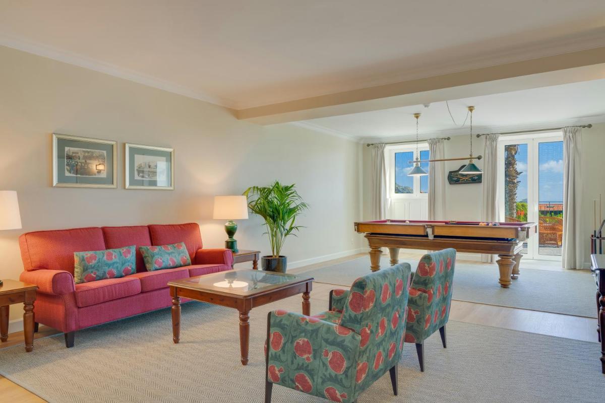 uma sala de estar com um sofá e uma mesa de bilhar em Pestana Quinta Perestrello no Funchal