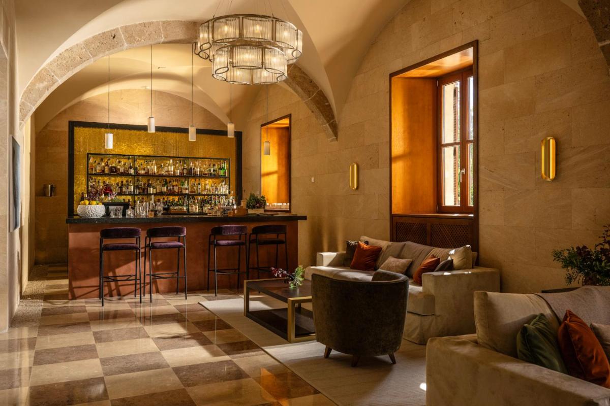 Un vestíbulo con bar en un edificio. en Castell Son Claret - The Leading Hotels of the World, en Es Capdellà