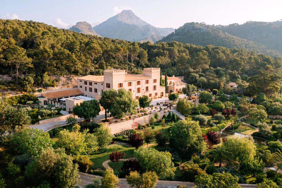 una vista aérea de un edificio con árboles y montañas en Castell Son Claret - The Leading Hotels of the World, en Es Capdellà