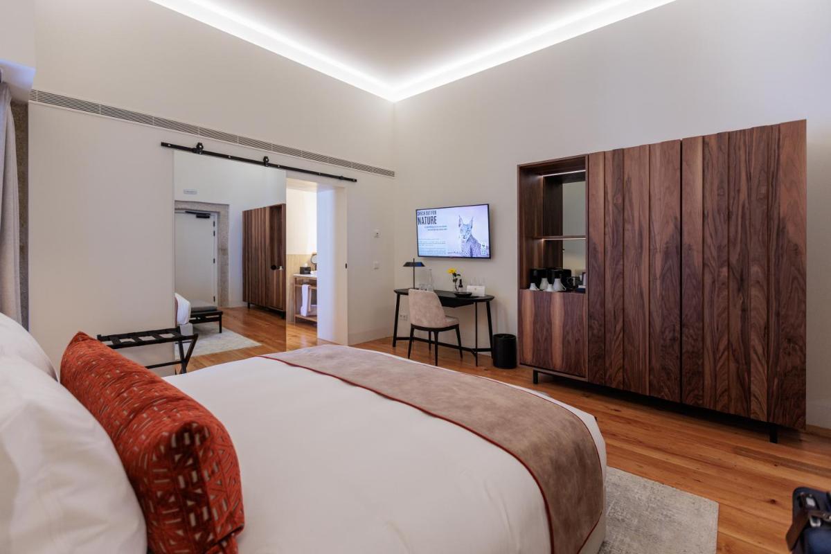 um quarto com uma cama grande e uma escrivaninha em MS Collection Arouca - Mosteiro de Arouca em Arouca