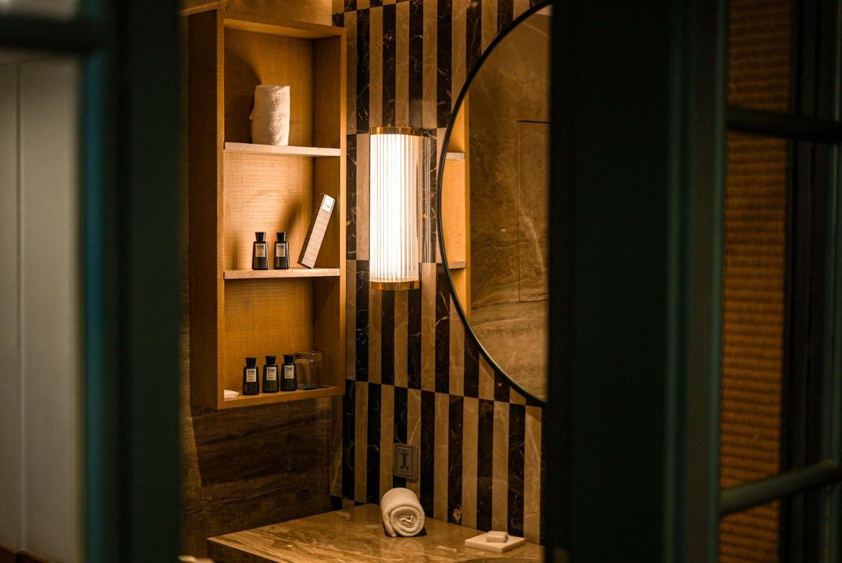 a bathroom with a mirror and a table with a sink at The Park Bangalore, MG Road in Bengaluru a bathroom with a mirror and a table with a sink at The Park Bangalore, MG Road in Bengaluru