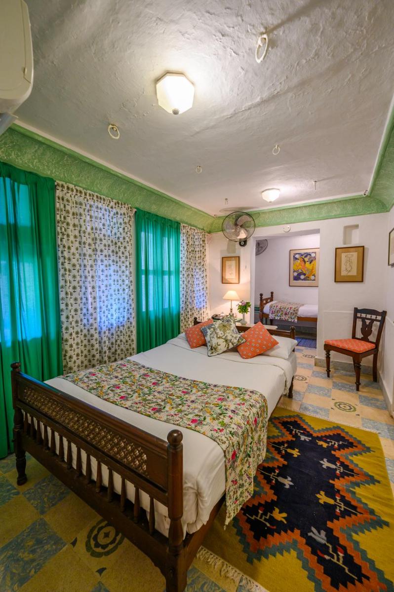a bedroom with a bed and a couch and a table at Neemrana Fort-Palace in Neemrana