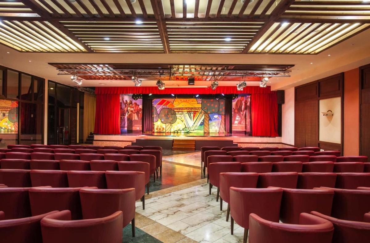 Un auditorio vacío con sillas rojas y un escenario. en Occidental Jandía Mar, en Morro del Jable 73 fotos más
