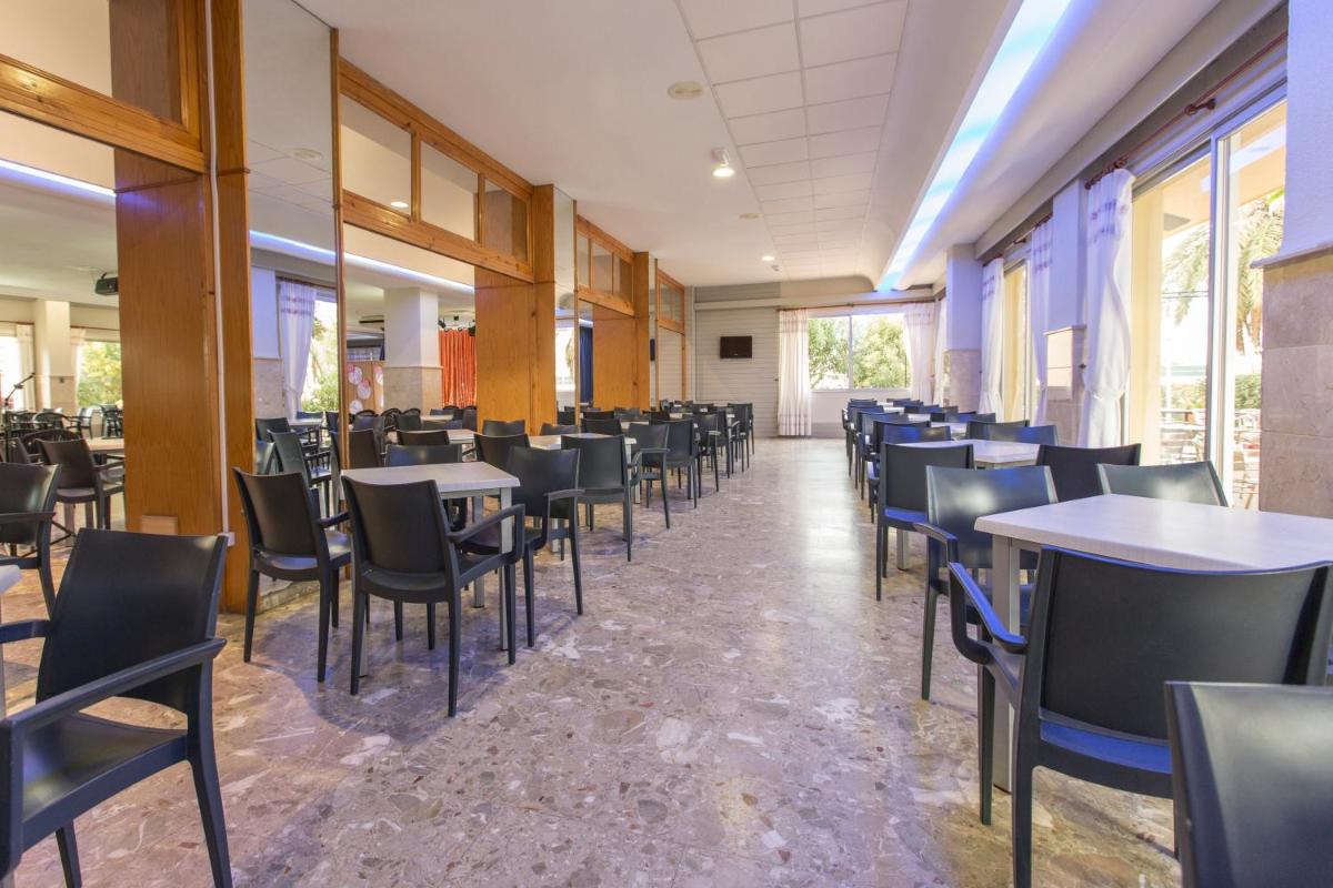 Un comedor vacío con mesas y sillas. en Hotel Tres Anclas, en Gandía