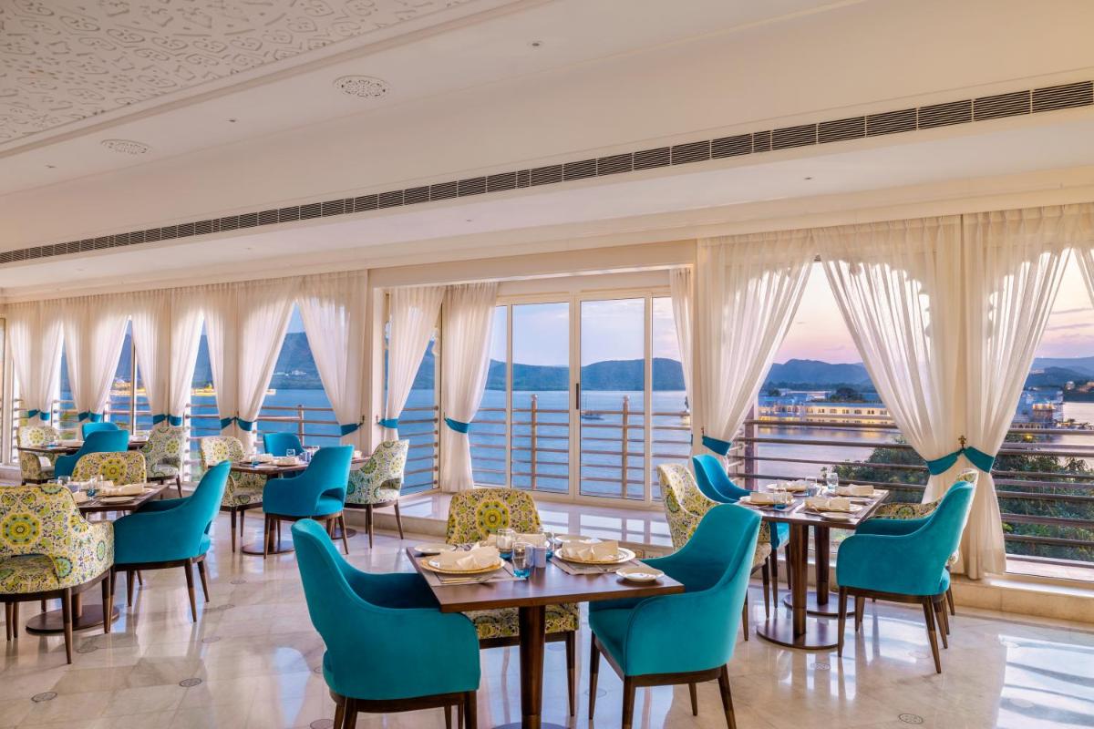 a restaurant with tables and chairs with a view at Taj Fateh Prakash Palace Udaipur in Udaipur