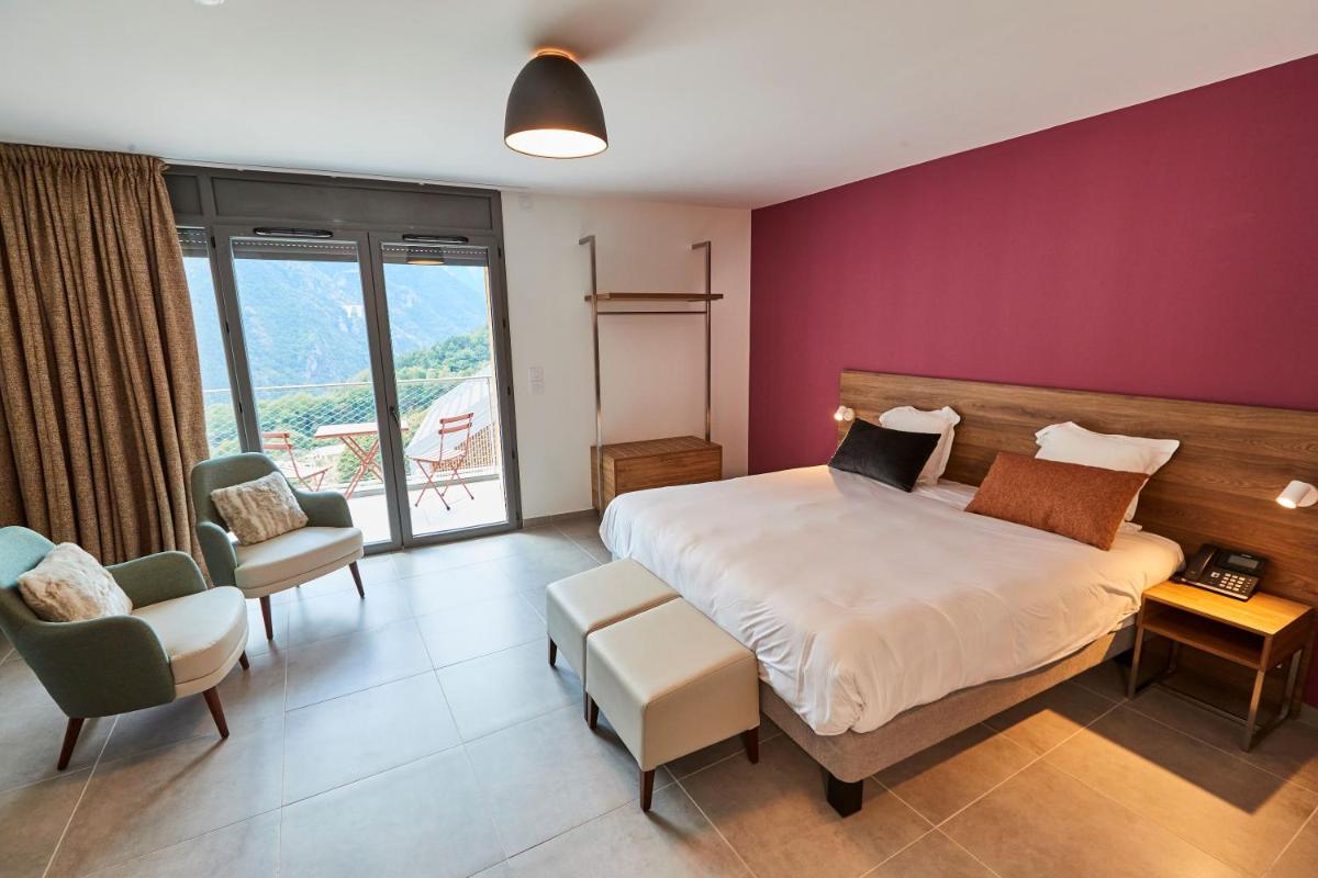 - une chambre avec un grand lit et un mur pourpre dans l'établissement Pure Thermal Residence, à Roquebillière