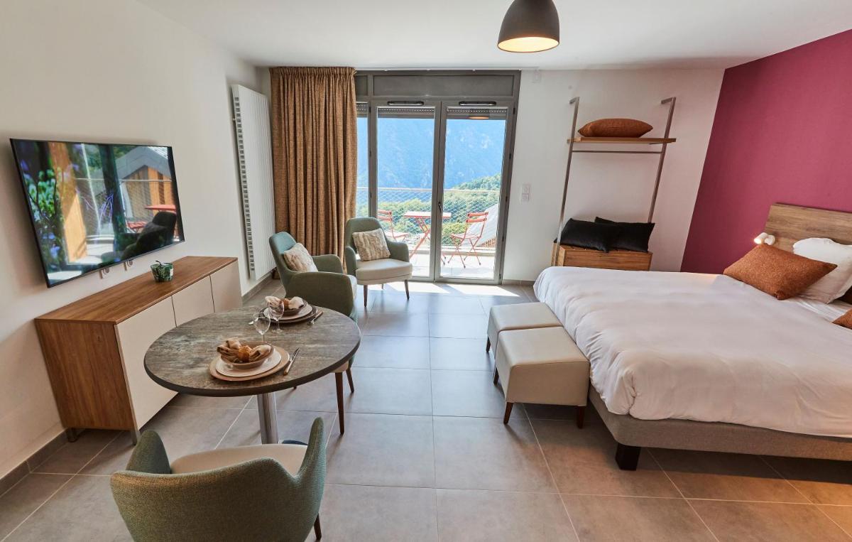 une chambre d'hôtel avec un lit, une table et des chaises dans l'établissement Pure Thermal Residence, à Roquebillière