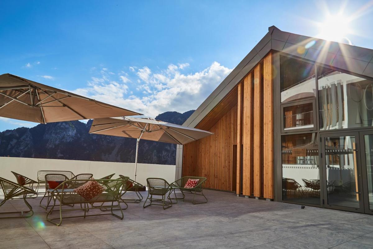 un patio avec des chaises, des tables et des parasols dans l'établissement Pure Thermal Residence, à Roquebillière