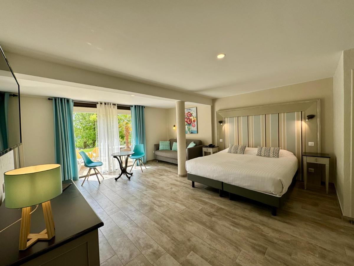 une chambre avec un lit et un salon dans l'établissement Hotel Restaurant Laborderie, à Tamniès
