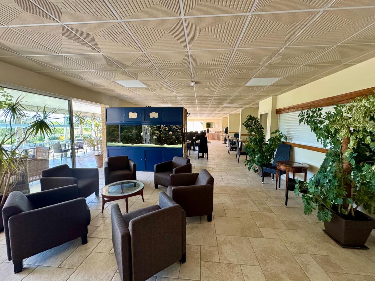 un hall d'entrée avec des chaises et des tables et un aquarium dans l'établissement Hotel Restaurant Laborderie, à Tamniès 41 autres photos