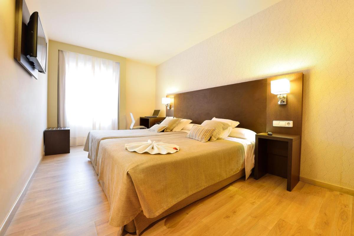 Una habitación de hotel con una cama grande y una ventana grande. en Hotel Spa Norat O Grove 3* Superior, en O Grove 43 fotos más