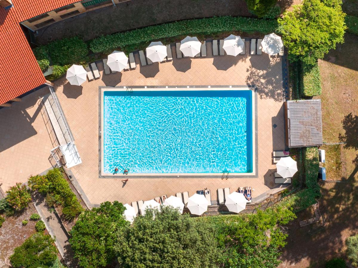 - une vue sur la grande piscine dotée de chaises blanches dans l'établissement Hôtel & Spa Vitalparc, The Originals Collection, à Lacanau-Océan