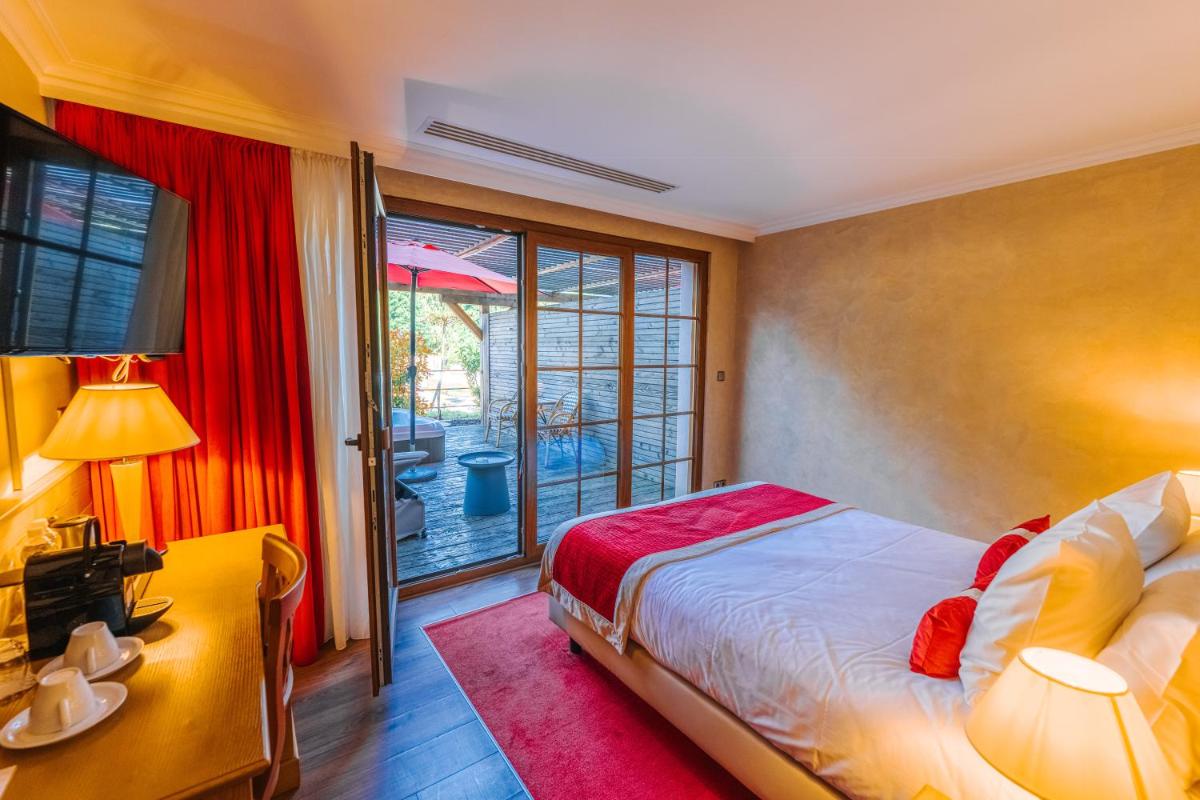 Un ou plusieurs lits dans un hébergement de l'établissement Les Violettes Hotel & Spa