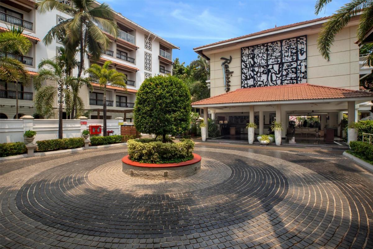 a courtyard with a tree in the middle of a building at Radisson Goa Candolim in Candolim