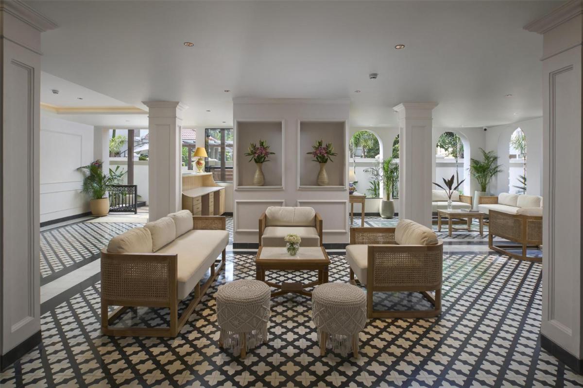 a living room with chairs and a couch and tables at Radisson Goa Candolim in Candolim