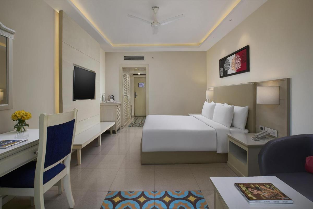 a hotel room with a bed and a desk at Radisson Goa Candolim in Candolim