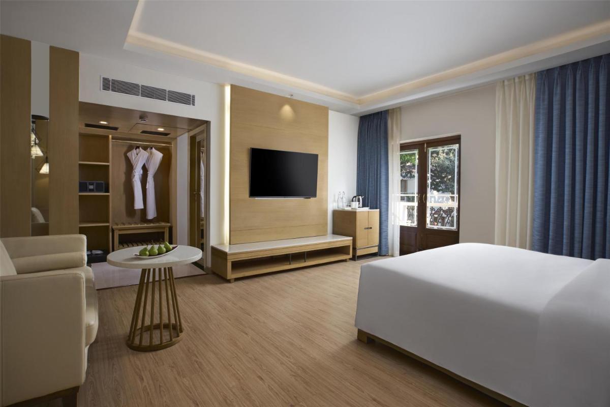 a hotel room with a bed and a television at Radisson Goa Candolim in Candolim