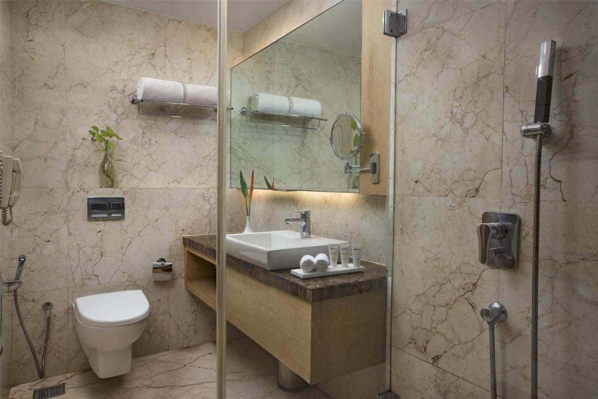 a bathroom with a sink and a toilet and a shower at Radisson Goa Candolim in Candolim