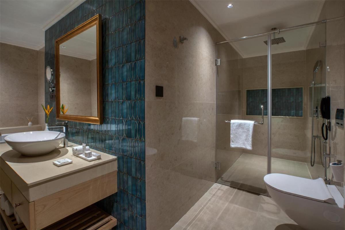 a bathroom with a sink and a toilet and a shower at Radisson Goa Candolim in Candolim