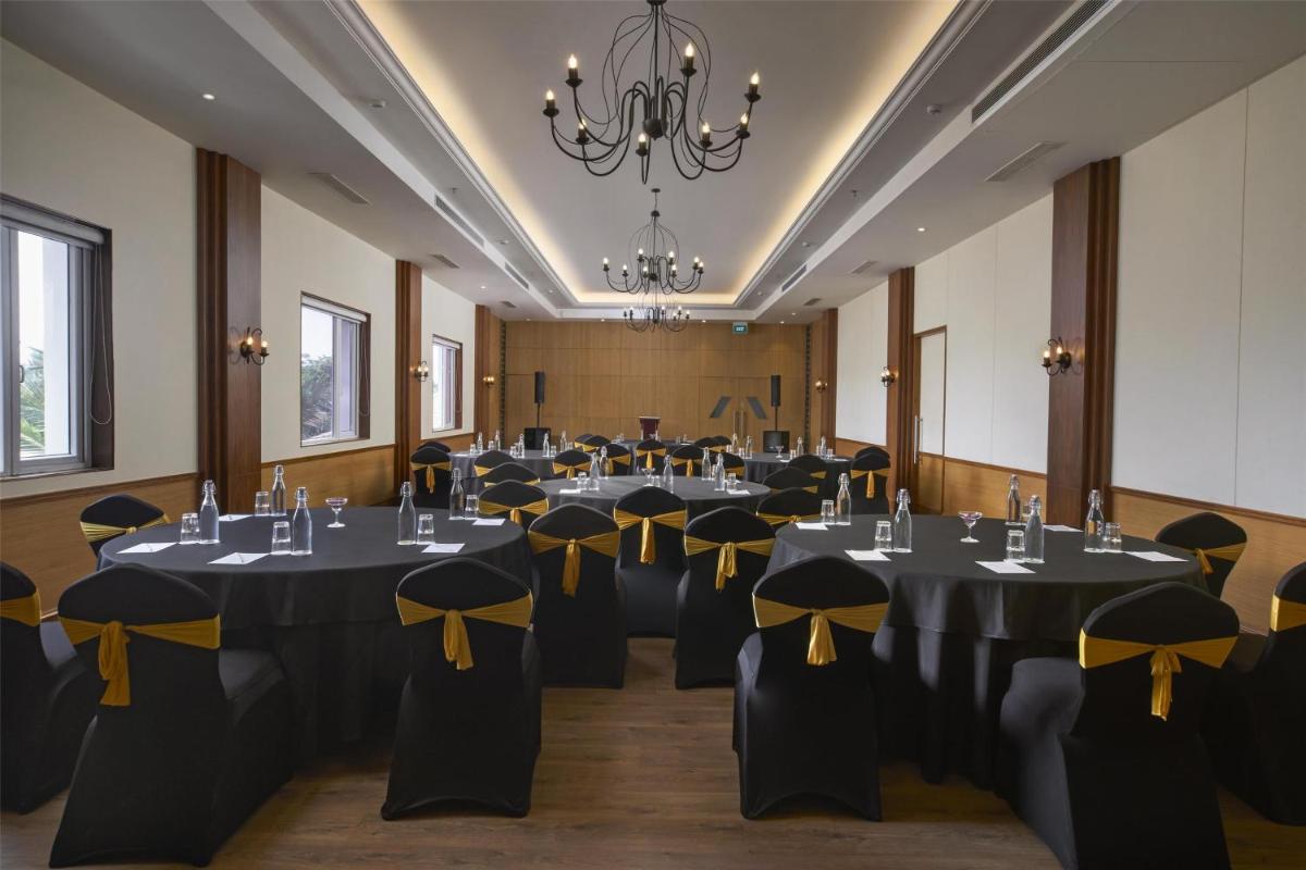 a conference room with tables and chairs with black and yellow bows at Radisson Goa Candolim in Candolim