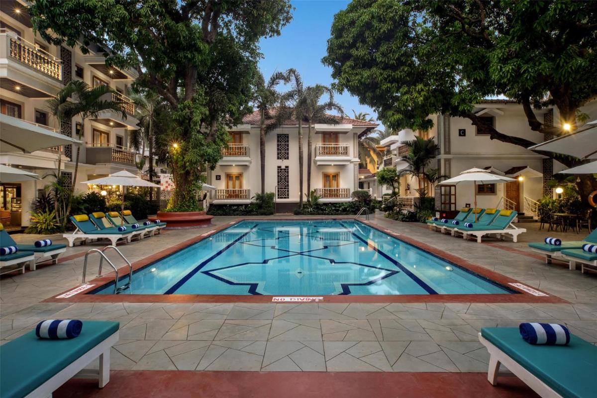 a swimming pool in front of a building at Radisson Goa Candolim in Candolim