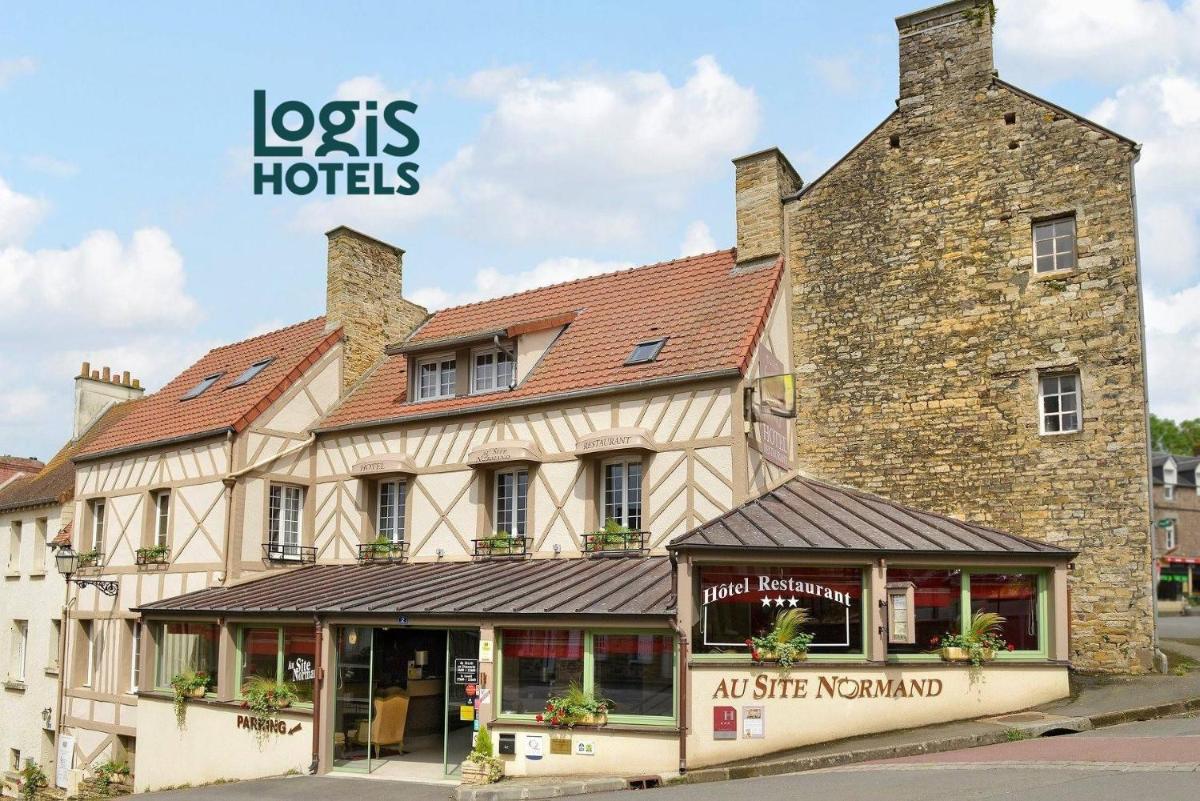 un vieux bâtiment en pierre avec un magasin en face de lui dans l'établissement Logis Hotel Spa Restaurant Au Site Normand, à Clécy