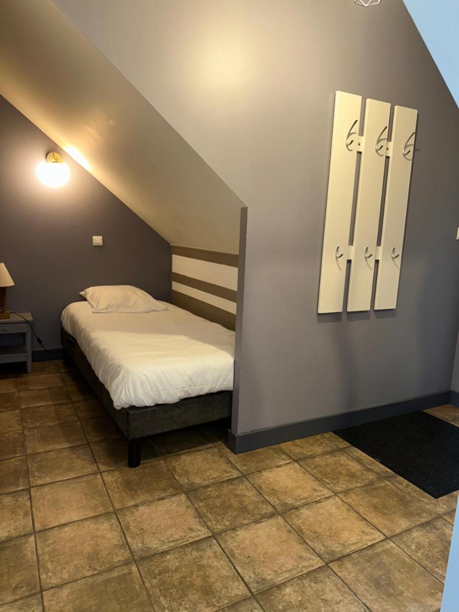 Un ou plusieurs lits dans un hébergement de l'établissement Logis Hôtel Volcan Sancy