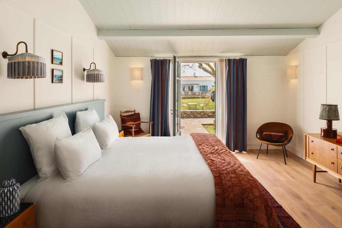 une chambre avec un grand lit blanc et une fenêtre dans l'établissement La Mission Hôtel & SPA - l'île d'Yeu, à L'Ile d'Yeu