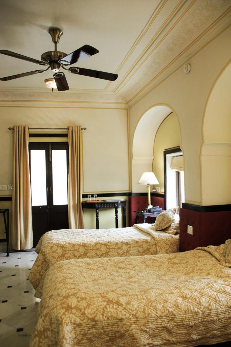 a hotel room with two beds and a ceiling fan at Royal Heritage Haveli - By Leisure Hotels in Jaipur