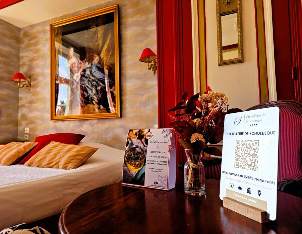 une chambre d'hôtel avec un lit et une table avec un panneau dans l'établissement Châtellerie De Schoebeque, à Cassel