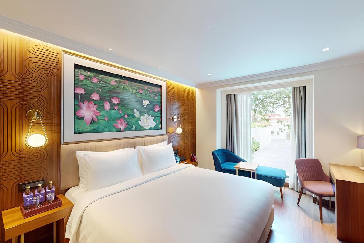 a hotel room with a white bed and a window at Radisson Blu Hotel & Suites GRT Chennai in Chennai