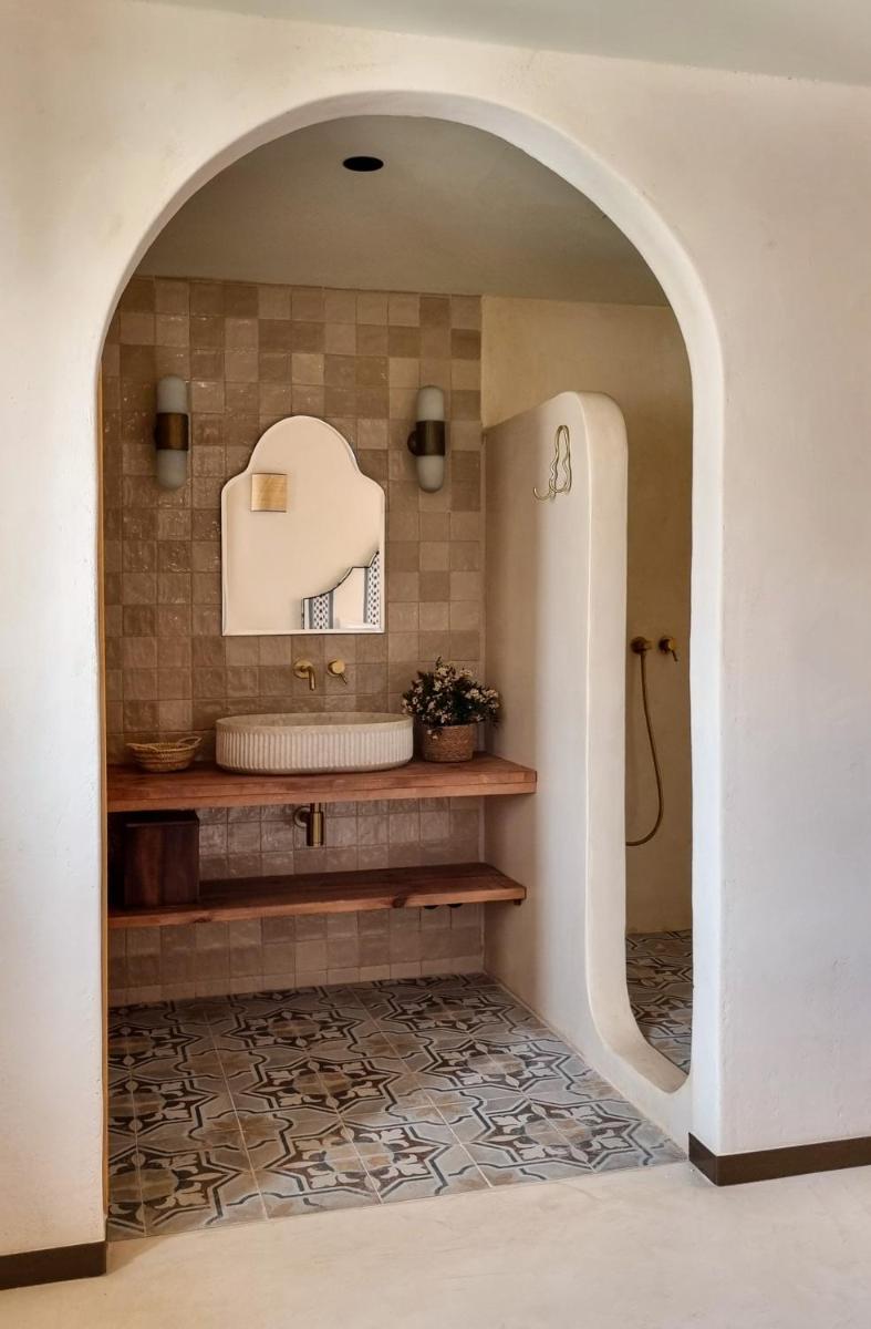 Un baño con un arco con bañera y lavabo. en Nomad Hotel & Spa Altea, en Altea
