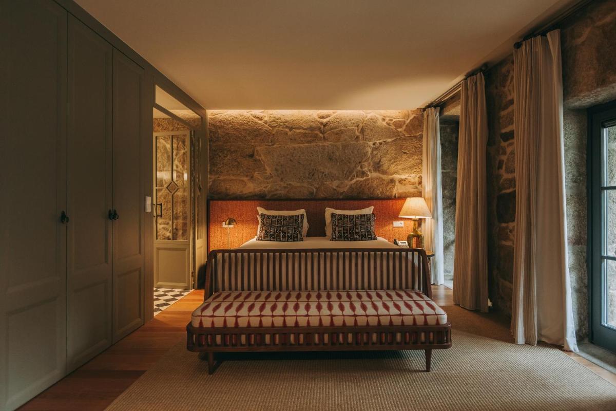 um quarto com uma cama e um sofá em uma sala em Torel Saboaria no Porto mais 115 fotografias