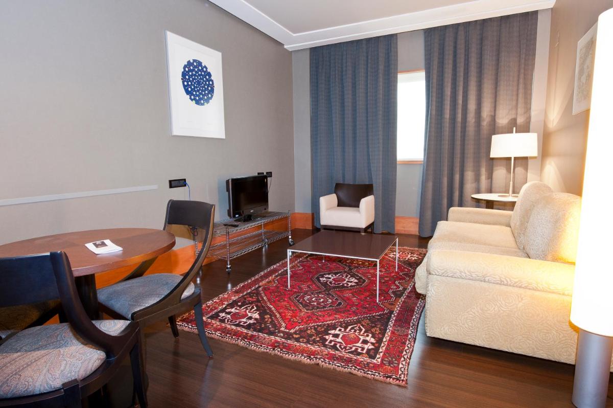 una sala de estar con un sofá y una mesa en Gran Hotel Lakua, en Vitoria-Gasteiz