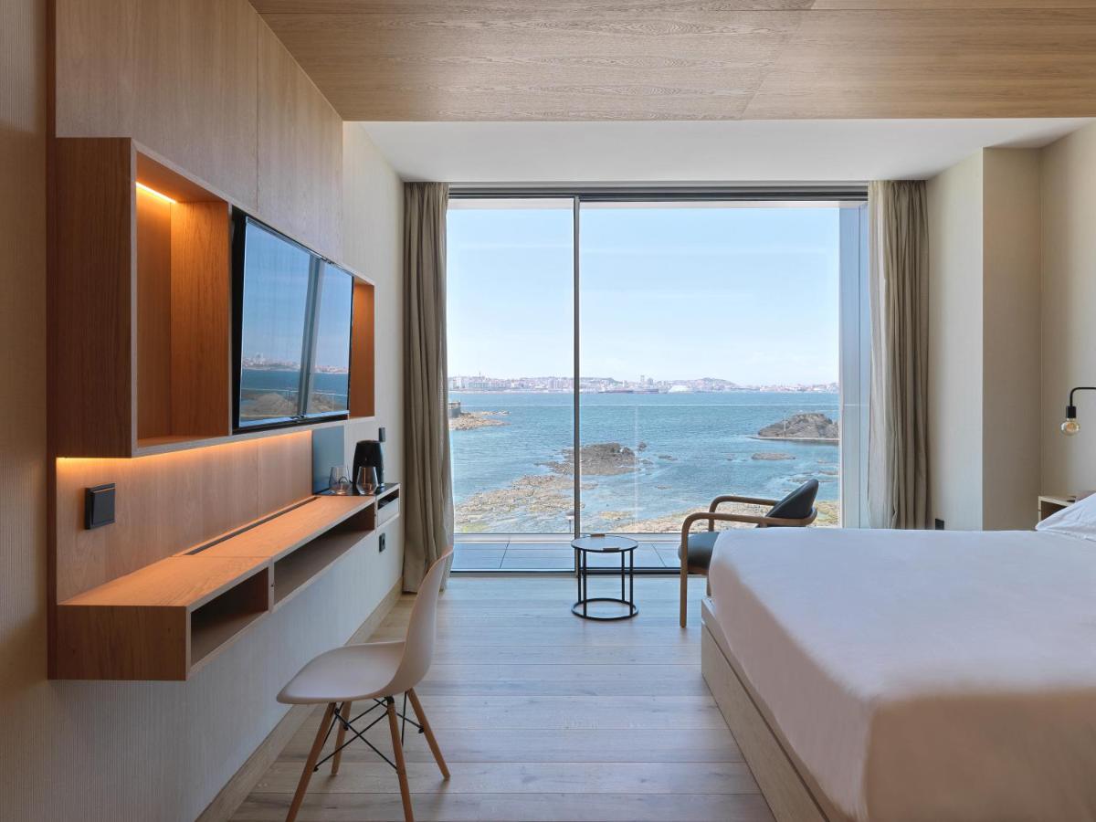 Un dormitorio con una cama y vista al mar. en Noa Boutique Hotel, en Santa Cruz de Oleiros