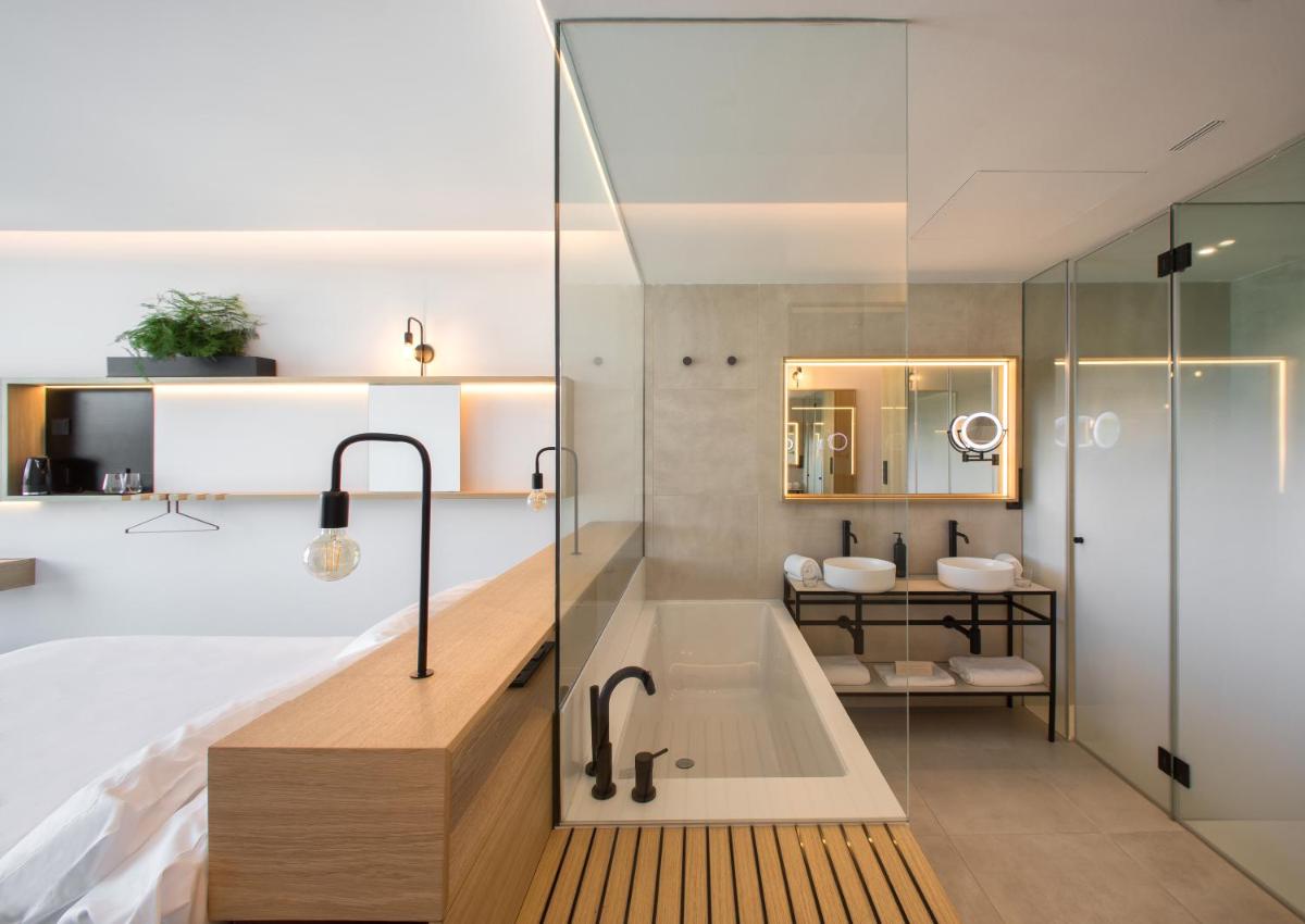 un baño con bañera y lavabo en Noa Boutique Hotel, en Santa Cruz de Oleiros 75 fotos más