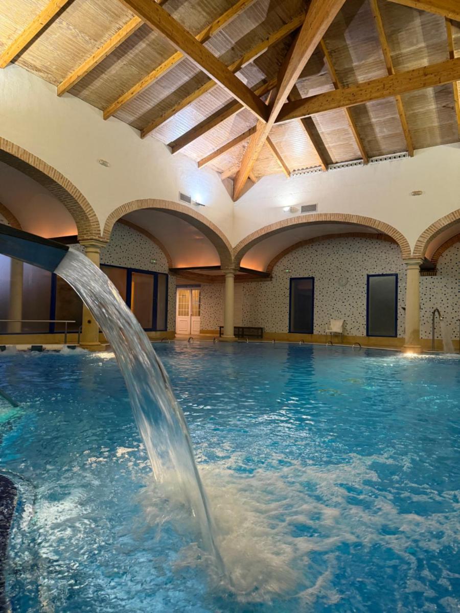 una piscina con una fuente de agua en un edificio en Balneario Cervantes, en Santa Cruz de Mudela