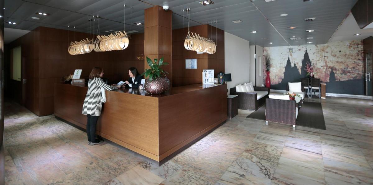 Una mujer parada en un mostrador en un salón en Hotel Spa Congreso, en Teo 44 fotos más
