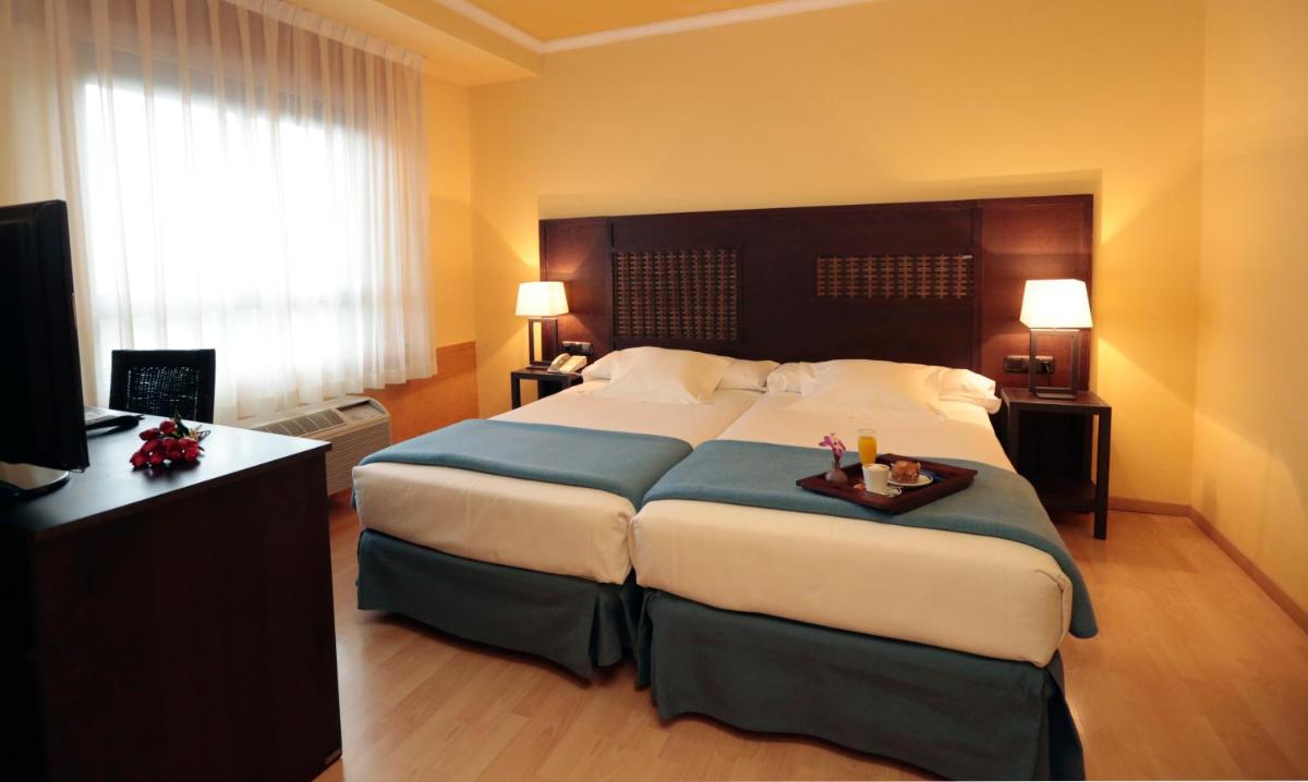 Cama o camas de una habitación en Hotel Spa Congreso