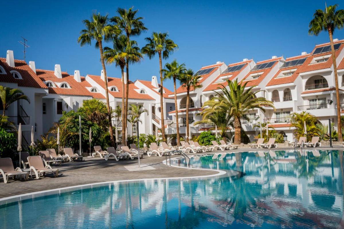 Una piscina frente a un hotel con palmeras. en Paradise Park Fun Lifestyle Hotel, en Los Cristianos