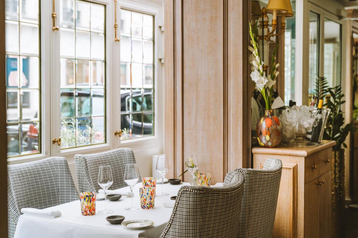 une salle à manger avec une table, des chaises et des fenêtres dans l'établissement Hotel Splendide Royal Paris - Relais & Châteaux, à Paris 28 autres photos