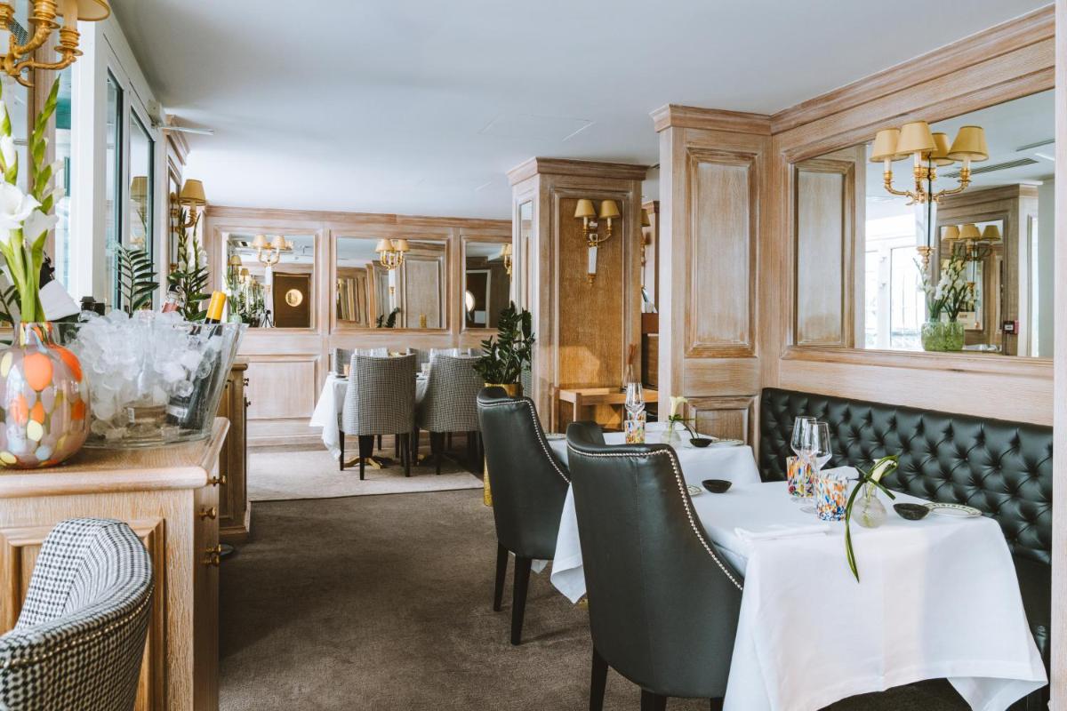 un restaurant avec deux tables et chaises dans une salle dans l'établissement Hotel Splendide Royal Paris - Relais & Châteaux, à Paris
