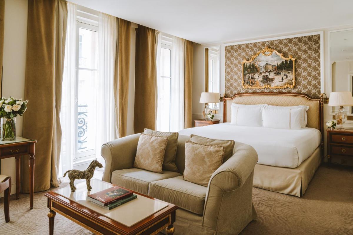 une chambre d'hôtel avec un lit et un canapé dans l'établissement Hotel Splendide Royal Paris - Relais & Châteaux, à Paris
