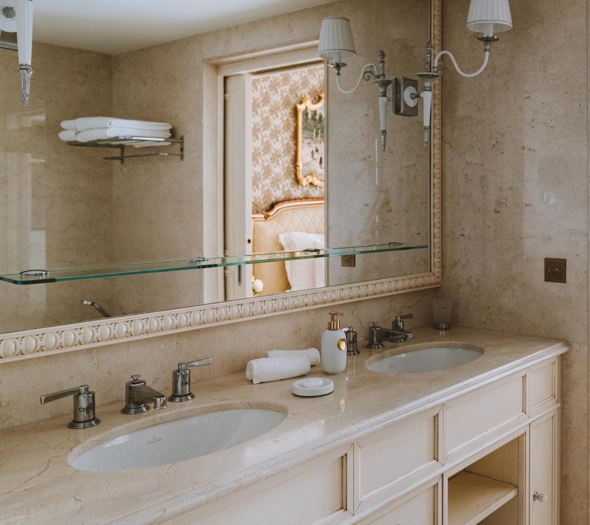 une salle de bain avec deux lavabos et un grand miroir dans l'établissement Hotel Splendide Royal Paris - Relais & Châteaux, à Paris