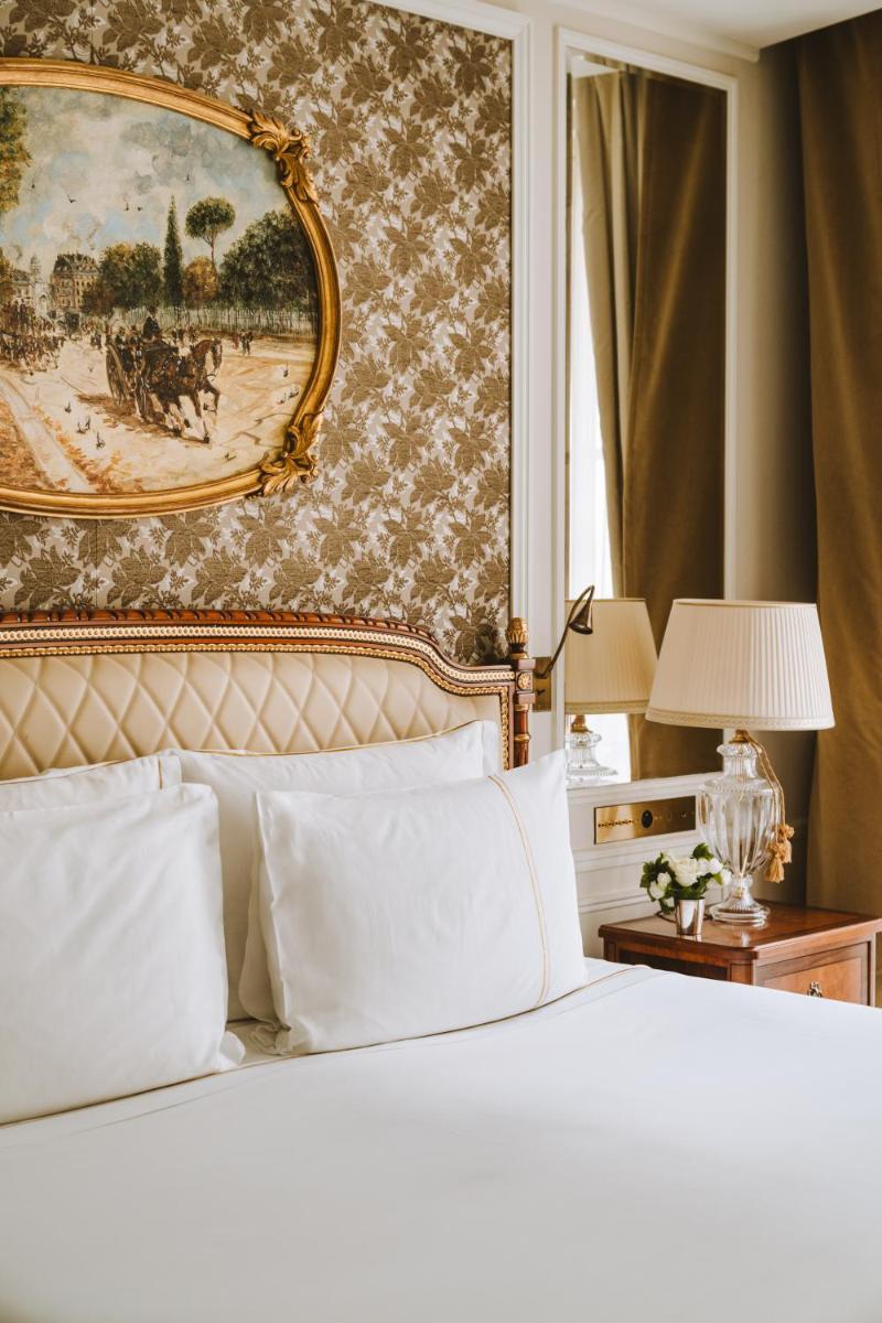une chambre avec un lit avec un tableau sur le mur dans l'établissement Hotel Splendide Royal Paris - Relais & Châteaux, à Paris